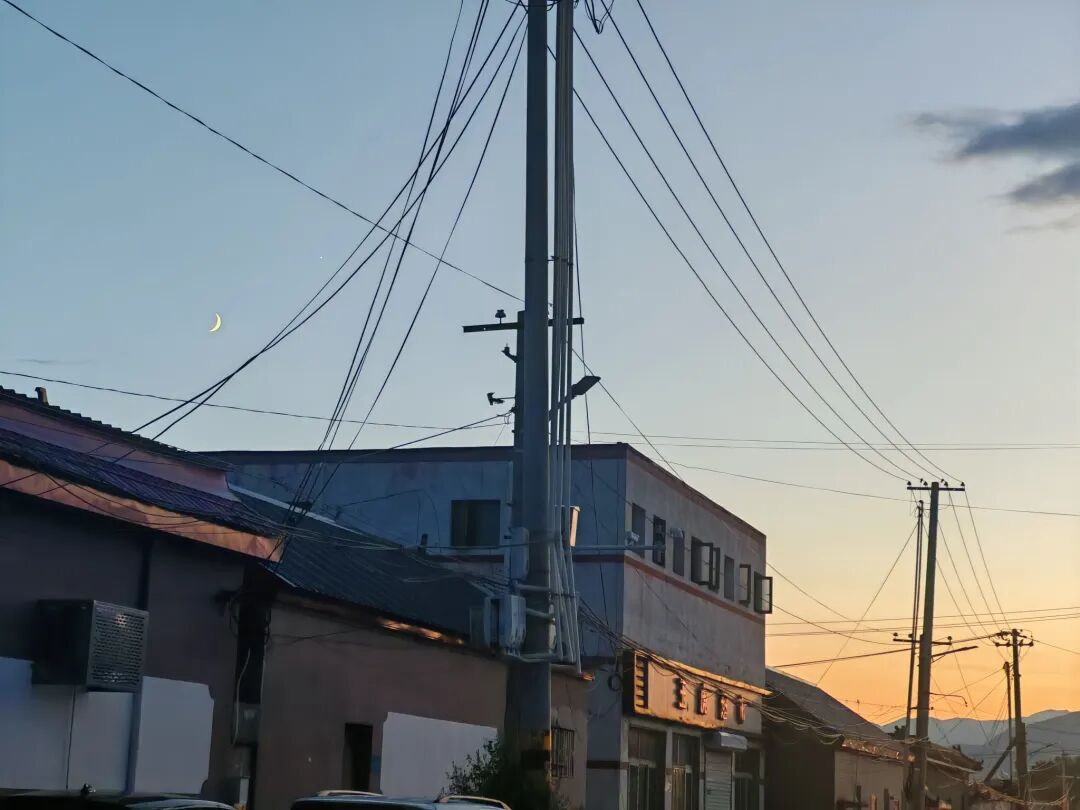 村庄上空的弯月与晚霞