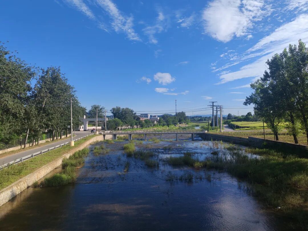 蓝天下的河道、村路与远山